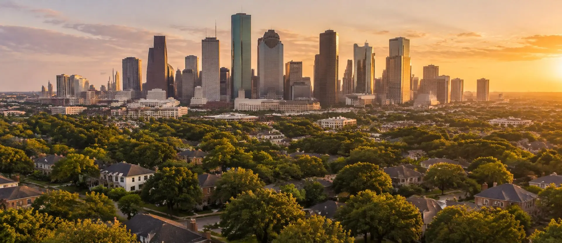 Houston skyline at golden hour above tree-lined residential neighborhoods